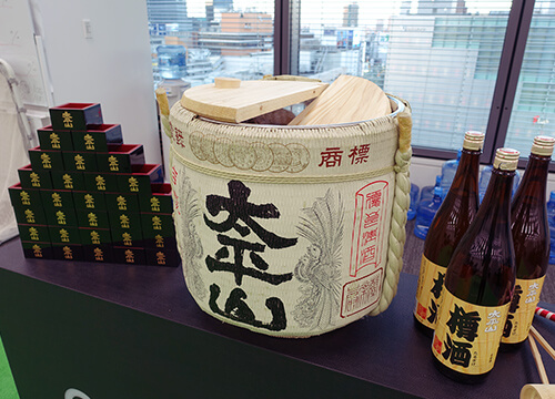 本社オフィスで新年会を開催し、鏡開きで日本酒をふるまいます。